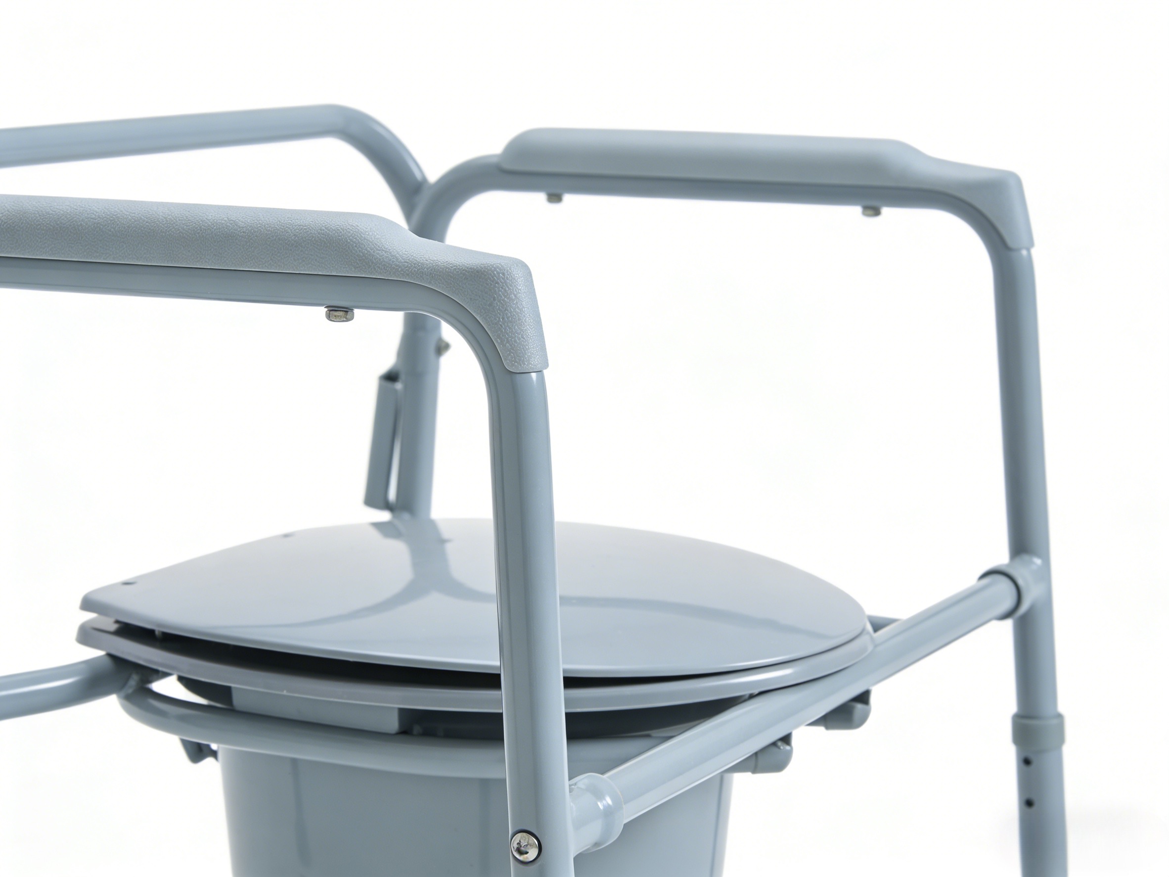 Close-up of precision welding and high-density padded armrests on a professional-grade bariatric folding commode chair.